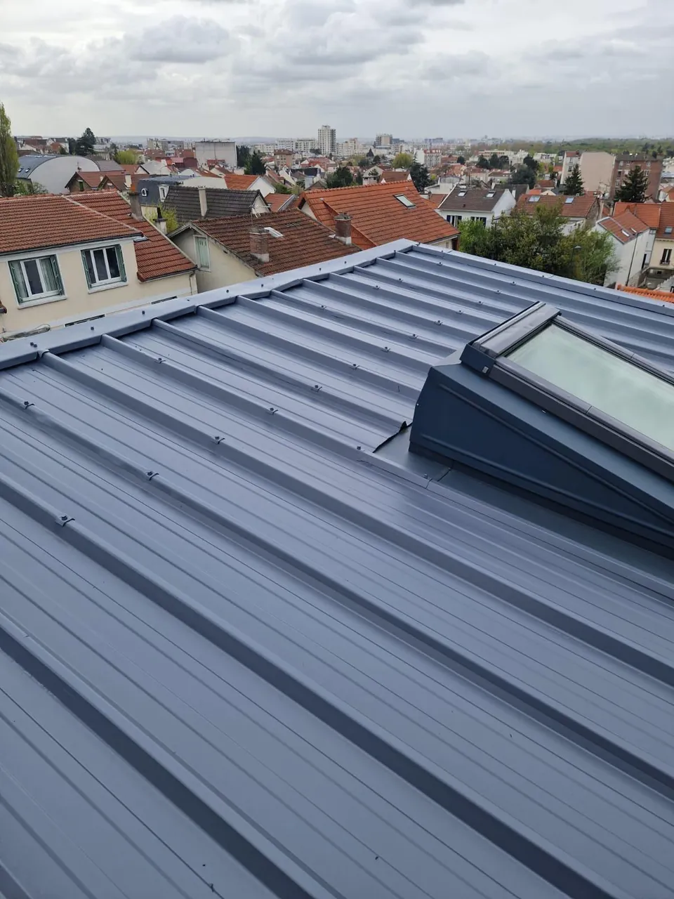 Couverture en zinc joint debout avec fenêtre de toit Velux, vue sur les Hauts-de-Seine